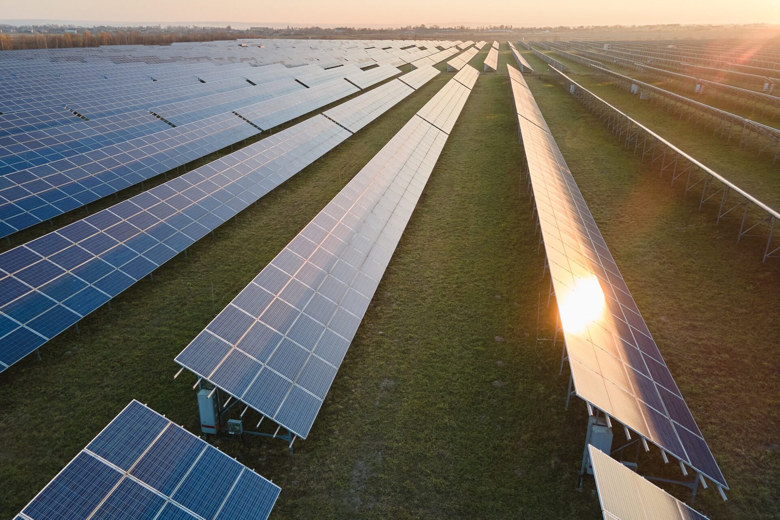 Aerial view of large sustainable electrical power plant with rows of solar photovoltaic panels for producing clean electric energy in evening. Concept of renewable electricity with zero emission.